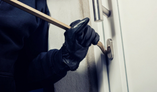 einbrecher öffnet eine wohnungstür